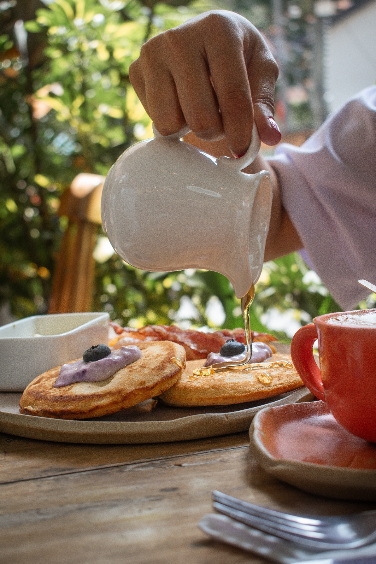 Sirviendo miel sobre pancakes en Amelier